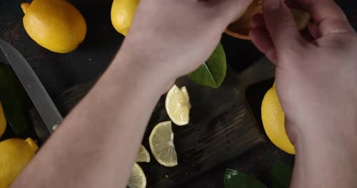 Las manos de los hombres sacan el limón en rodajas de la tabla