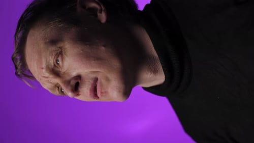 Close Up of Tired Man Against Purple Background