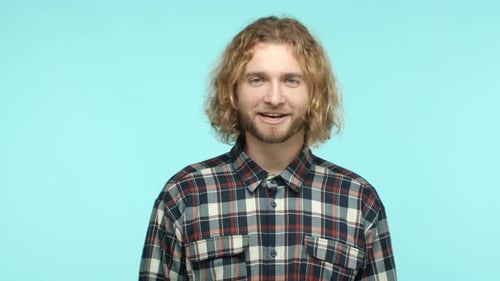 Man With Curly Hair Talking on Blue Background