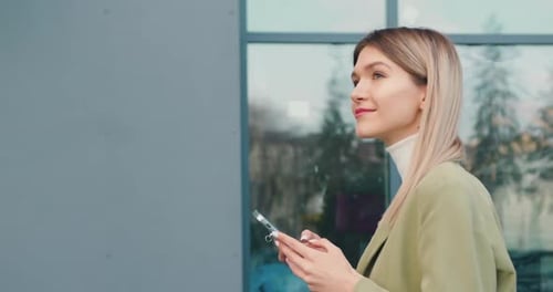 Woman Walks on Street with Smartphone and Chatting with Friends Using Smartphone.