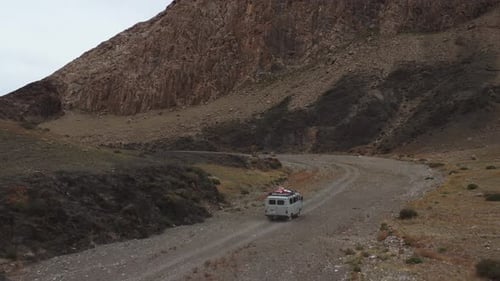 Offroad Vehicle Goes on a Dirt Road Among the Mountains