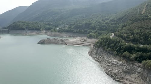 Aerial Drone View Over Reduced Water Levels of the Lake Ayous with the View of a Dam in the Distance