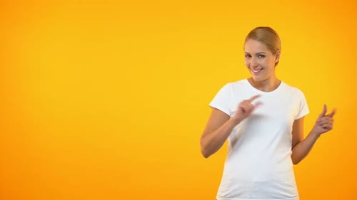 Attraktive weibliche Zeigefinger auf orangefarbenem Hintergrund, Vorlage
