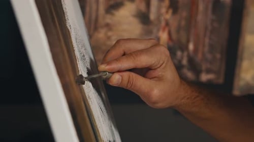 Artist Applies Oil Paint on Canvas with Small Metal Spatula Drawing Picture in Light Studio Extreme