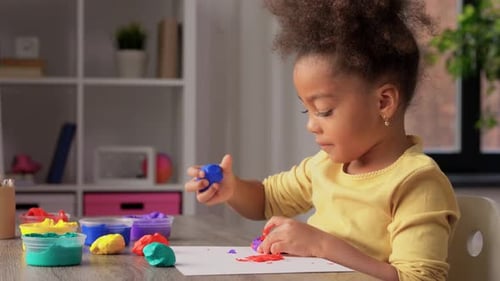 Girl Making Art with Colorful Clay at Table