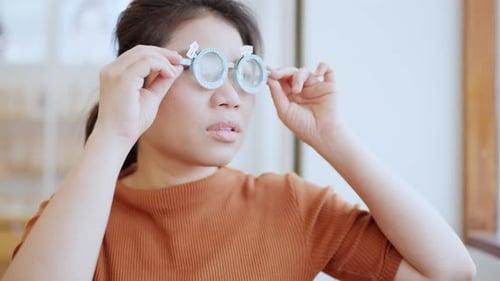 Woman Looks Through Trial Frame During Eye Exam