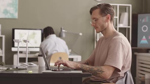 Alternative Energy Engineer Working on Laptop in Office