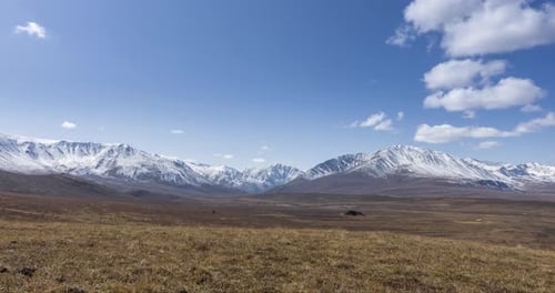Timelapse of Sun Movement on Crystal Clear Sky with Clouds Over Snow Mountain Top