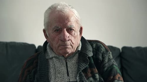 depressed old man looks at camera