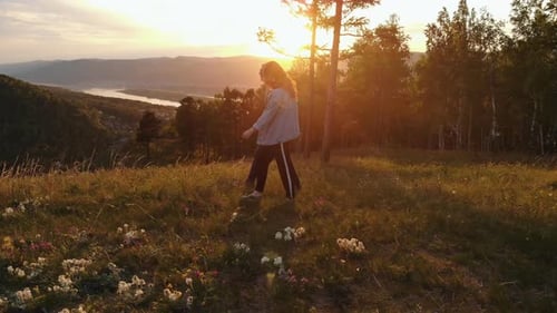 Happy Young Couple Walking on Mountain at Sunset