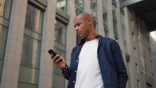 Young Man Uses Phone in the City