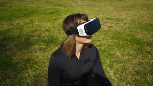 Young Woman in Sportswear Using Virtual Reality Headset in Park