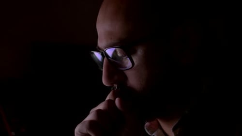 Eine Nahaufnahme eines indischen Mannes, der tief in Gedanken versunken ist, sein Verstand an einem dunklen Ort, als er ängstlich auf seinen tippt