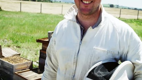 Confident beekeeper smiling at camera