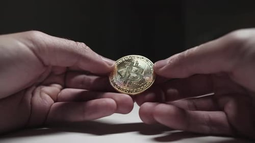 Close Up of Hands Rotating Bitcoin