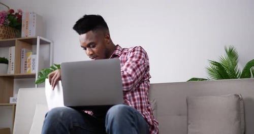 Young Adult Working from Home on Laptop