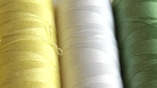 Top view of colorful thread spools isolated on white background