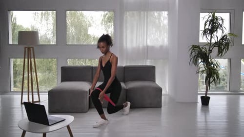 Young Woman Exercising at Home with Resistance Band