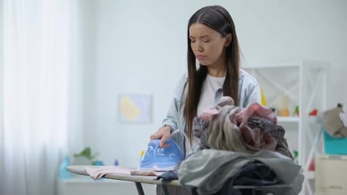 Woman Ironing Clothes At Home