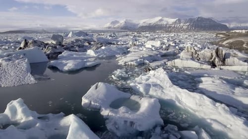 Aerial view of Jokulsarlon glacier lagoon with iceberg floating and mountains