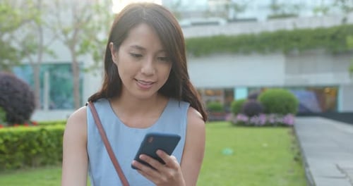 Woman look at the mobile phone in park