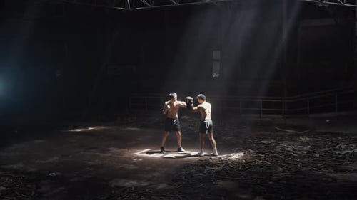 4K Asian man boxer do practicing boxing with male coach in abandoned building.