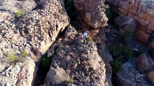 Male rock climber standing over a rocky mountain 4k