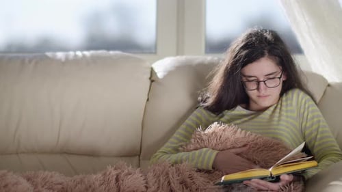 Woman Reading a Book on Couch