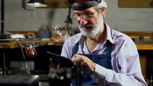 Goldsmith using digital tablet in workshop 4k