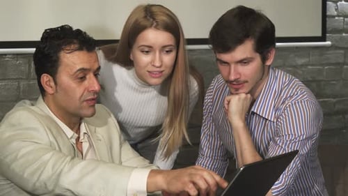 Three People Working Together on a Laptop