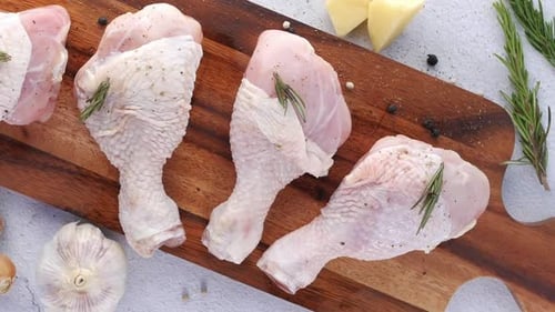 Raw Chicken Drumsticks with Fresh Ingredients on Cutting Board