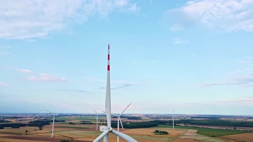 Windmill turbine in the field at summer day. Rotating wind generator