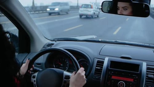 Woman drives car on highway during daytime