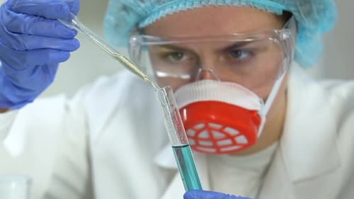 Concentrated Chemist Mixing Colorful Reagents Observing Reaction, Experiments