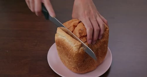 Close Up of Loaf of Bread Being Sliced