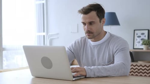 Adult Man Working On Laptop in Office