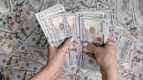 Woman Counting US Dollars on Pile of Cash Money Background