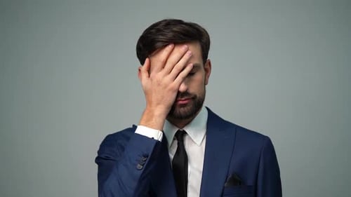 Man in Suit with Hand on Face