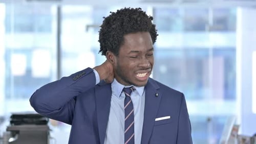 Tired African American Businessman Having Neck Pain in Office