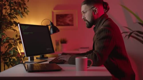 Homem usando computadores para programação