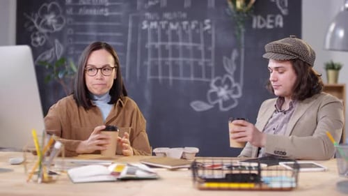 Coworkers Talking at Desk in Modern Workplace