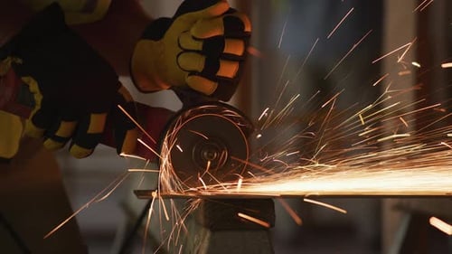 Worker Cuts Metal with Cutting Wheel Producing Sparks