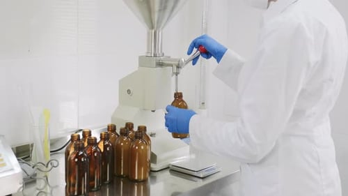 Medical Professional Filling Bottles in Sterile Lab