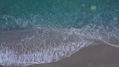 Top Down View Turquoise Waves Reaching Shore Break on Empty Pebble Beach. Pure Sea From Bird's Eye