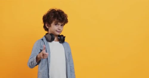 Smiling Boy Poses with Finger Gun Gesture