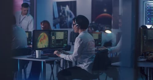 Woman Using Computer During Spacecraft Launch Near Team