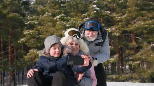 Happy Family Poses for Selfie in Snowy Forest