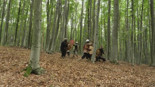 Medieval Reenactors Fight with Swords and Shields in Forest