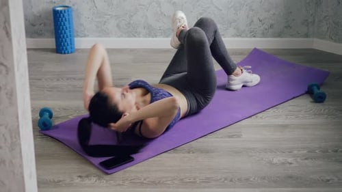 Una mujer practica deportes en casa