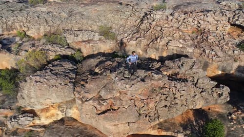 Male rock climber standing over a rocky mountain 4k